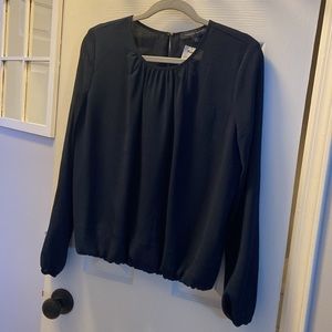 Long sleeve navy crinkle texture top with blouson styling.